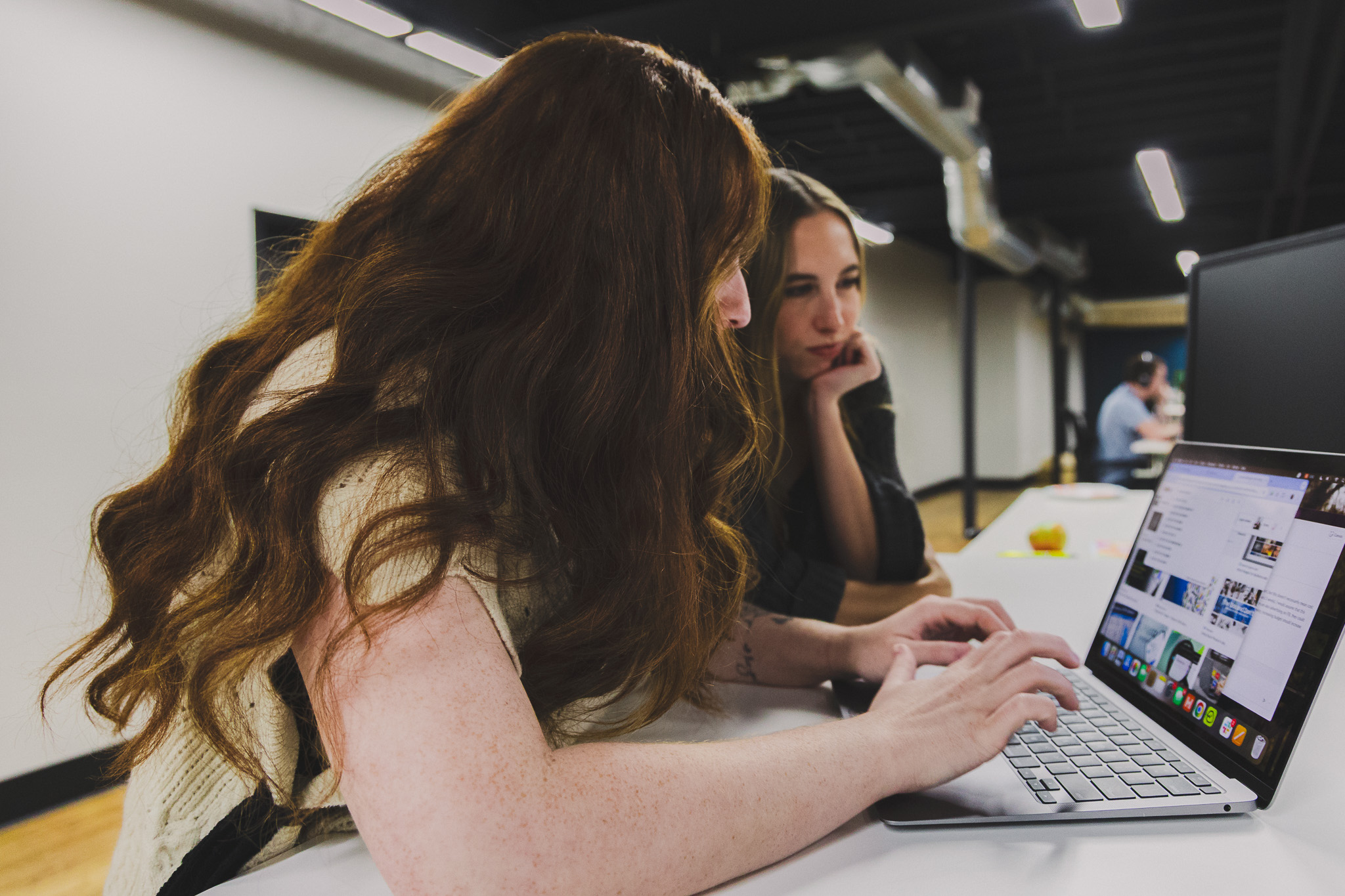Five Door Media team members working together on laptops in the office
